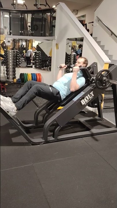 Plate-loaded hack squat machine on the gym floor