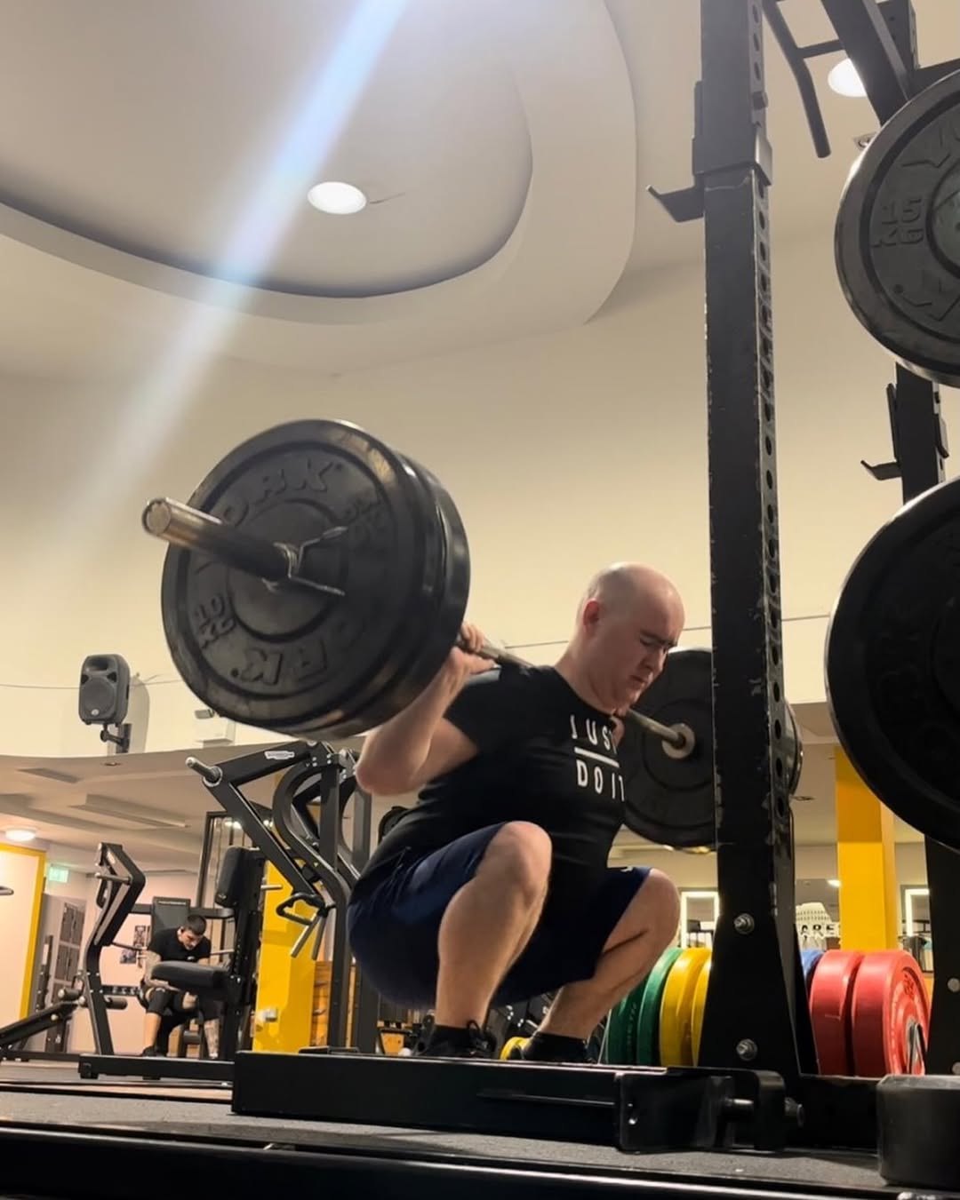 Squat rack in use on the gym floor